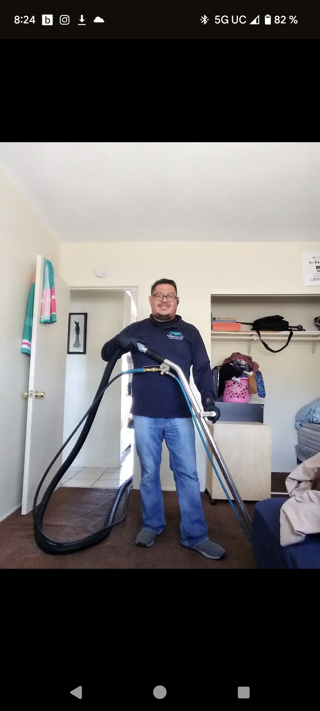 Persona sosteniendo equipo de limpieza de alfombras en una habitación.